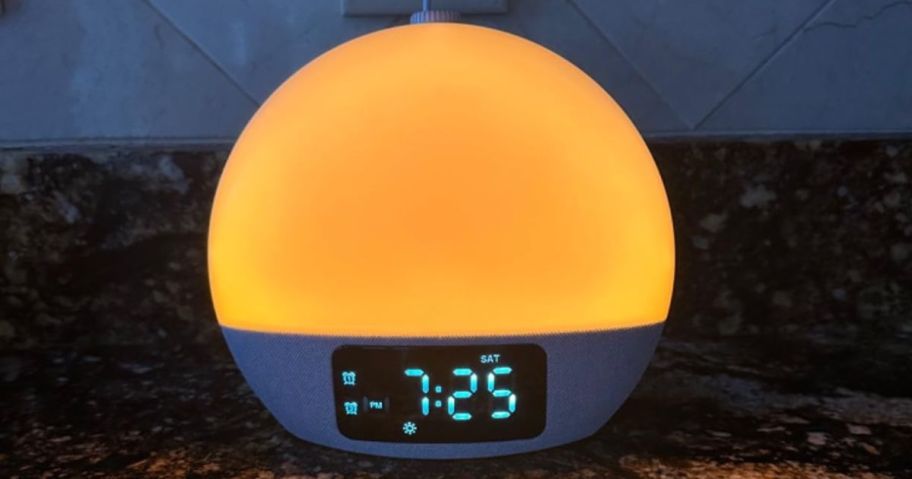 A sunrise alarm clock with a glowing orange light