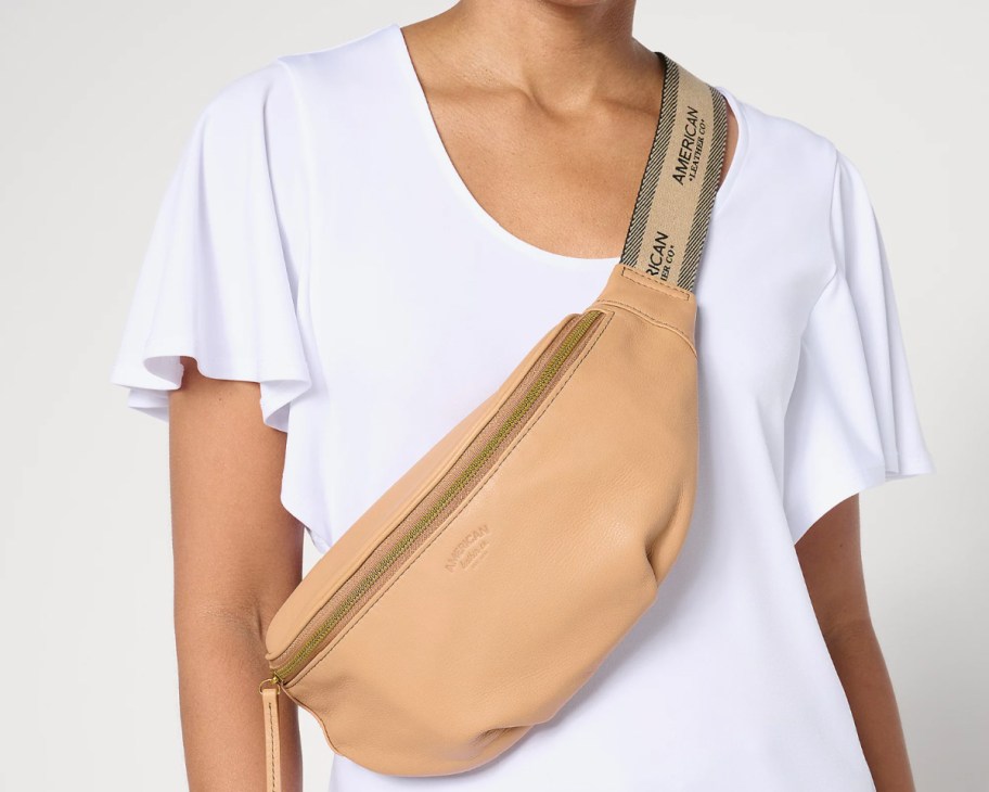 woman wearing tan leather sling bag