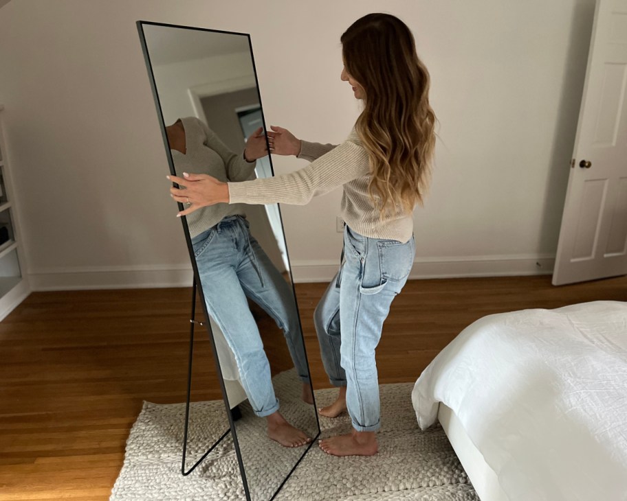 woman standing in front of floor length mirror