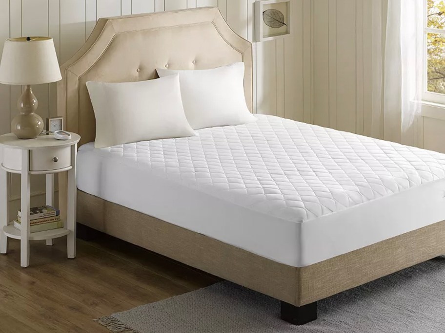 white mattress pad on bed 