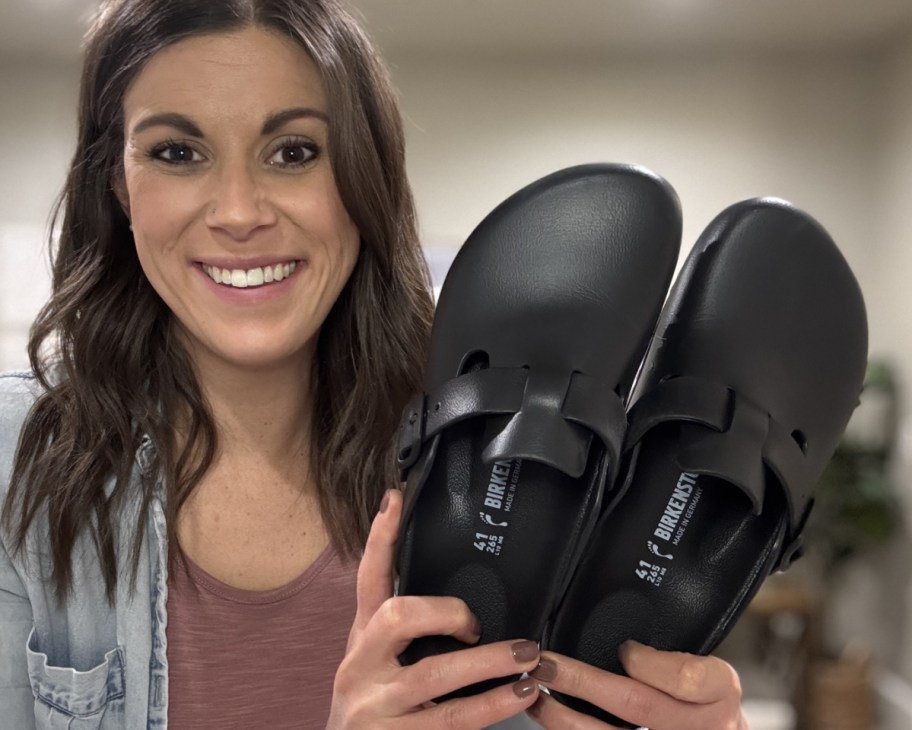 woman holding up birkenstock mules