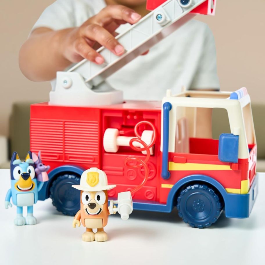  a toddler playing with the bluey firetruck