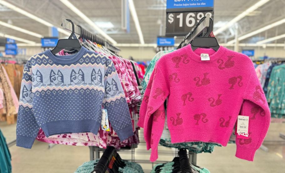 little kids bluey and barbie sweaters on a clothing rack in a store sweater