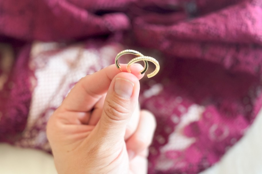 fingers holding hoop earrings