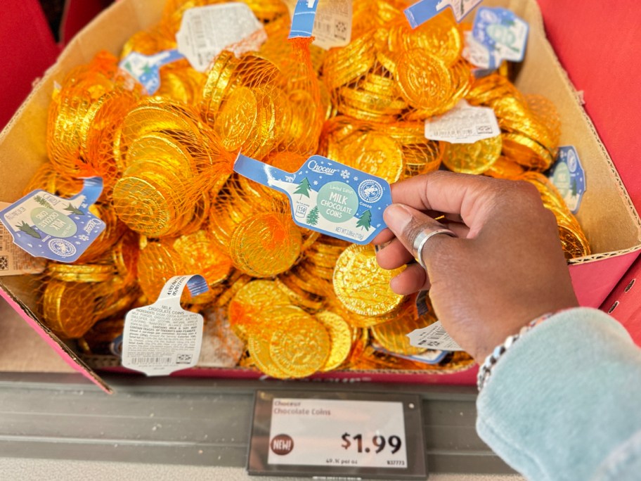 hand reaching for chocolate coins in pile