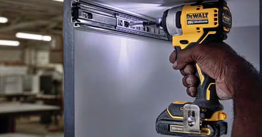 hand holding dewalt yellow and black drill 