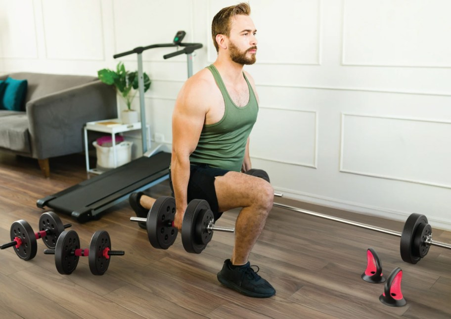 man working out with multiple dumbells