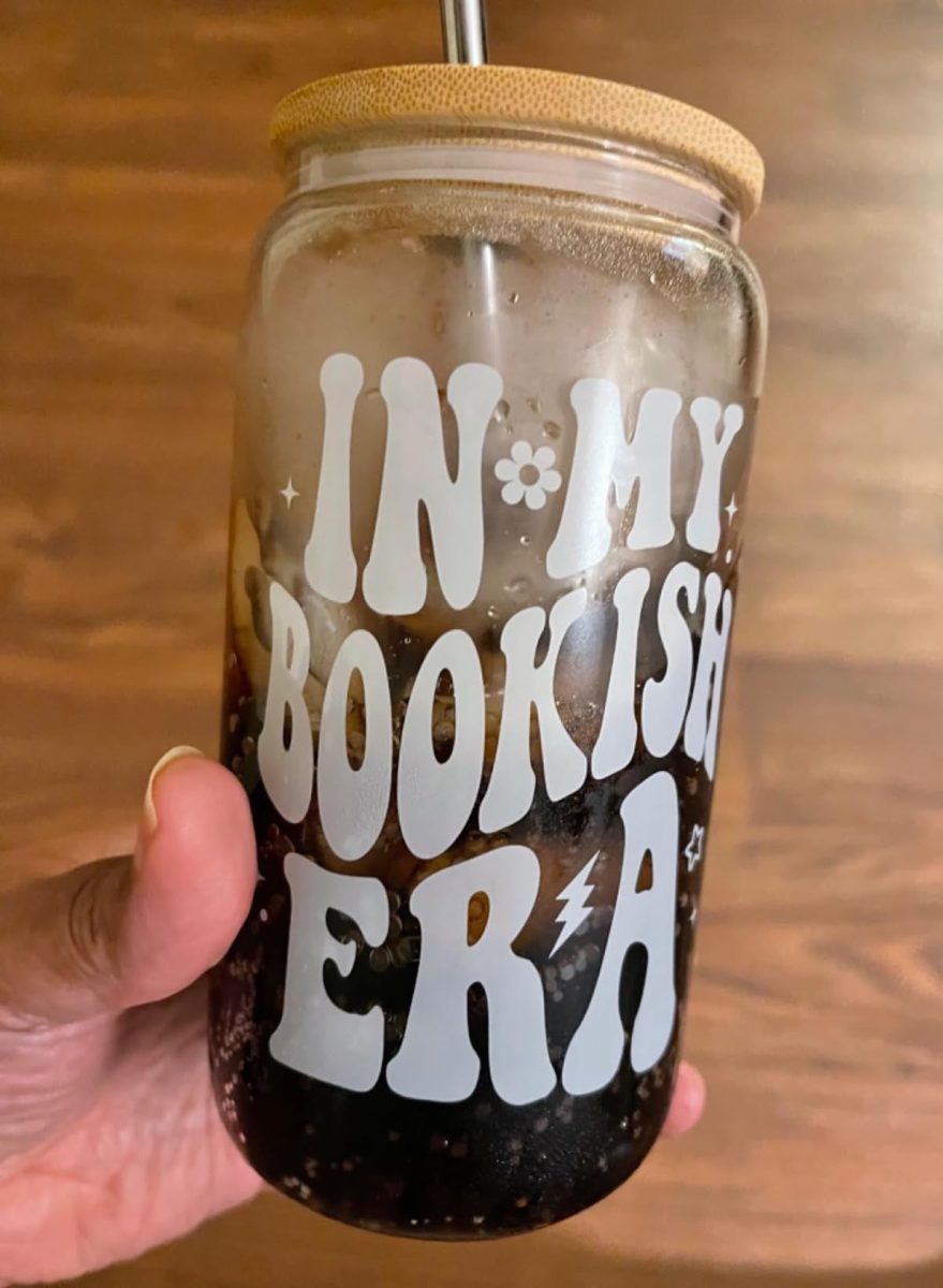 hand holding in my bookish era glass mug with wood lid 