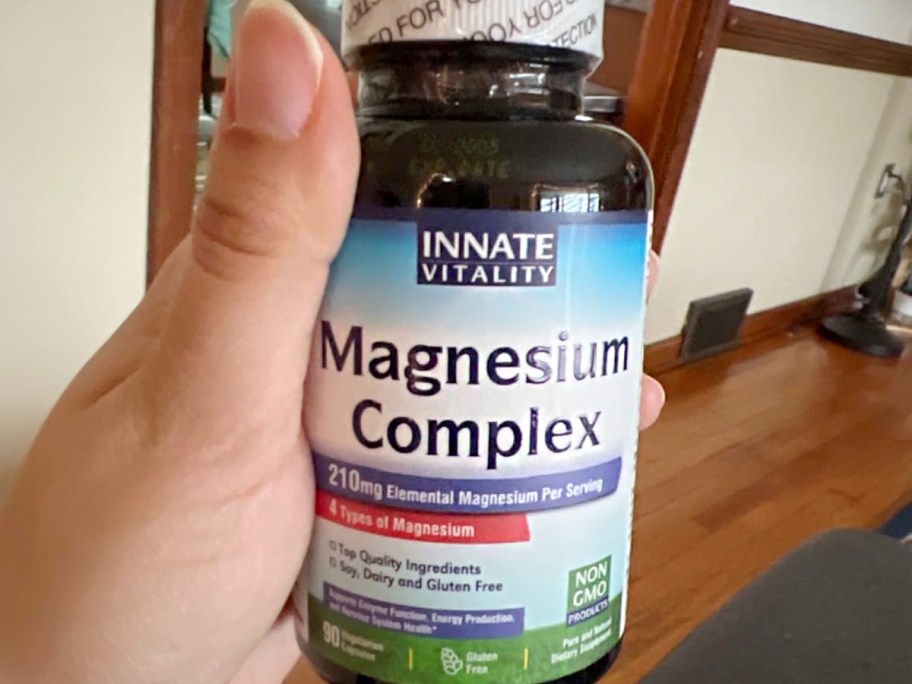 hand holding magnesium onlineplex bottle 