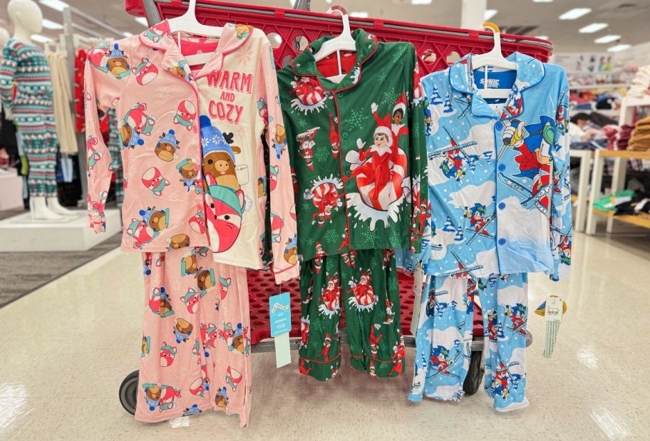 three sets of kids pajamas hanging on the side of a target cart