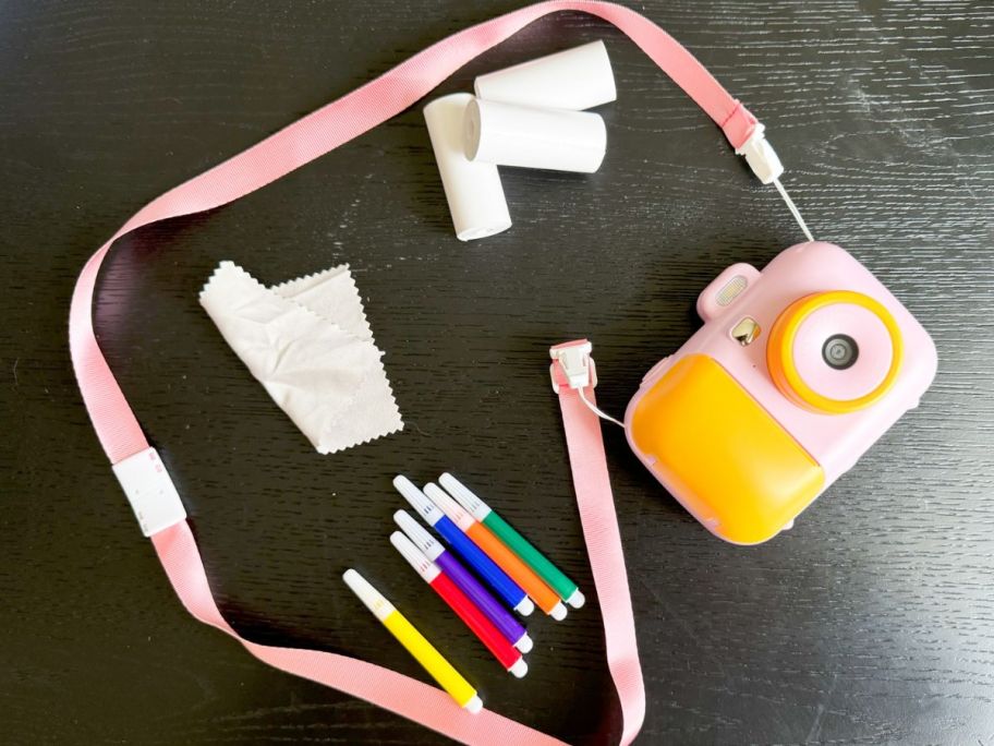 kids instant camera displayed on the table with all the items it includes