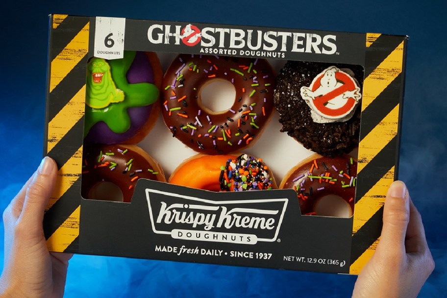 hand holding up a box of krispy kreme ghostbusters doughnuts