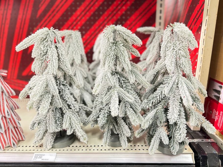 unlit Flocked Downswept Pine Artificial Christmas Trees on a store shelf