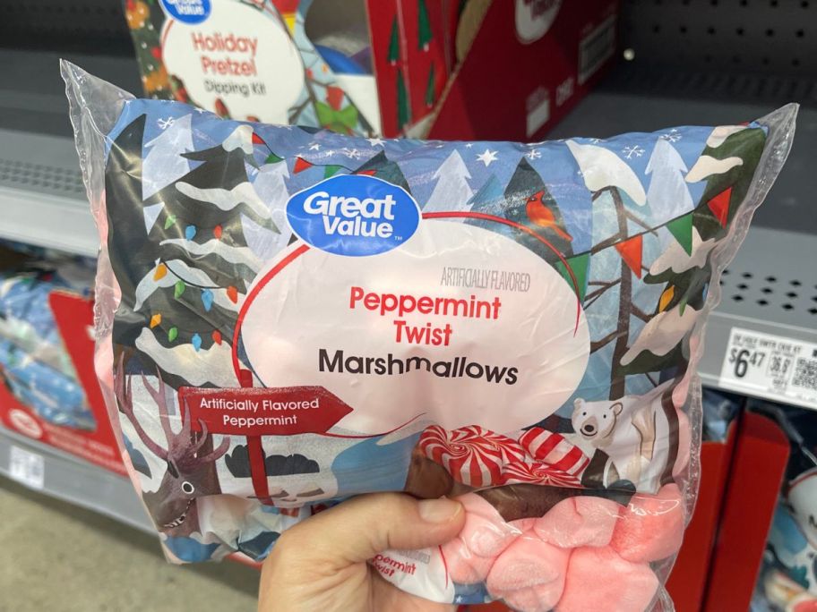 a womans hand holding a bag of peppermint marshmallows