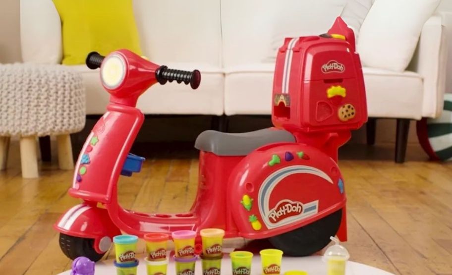 red play doh scooter with accessories laying out in front of it