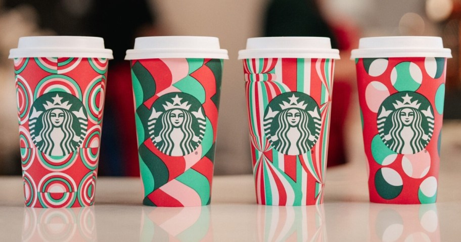 4 Starbucks to go cups in new Holiday 2024 designs on a counter