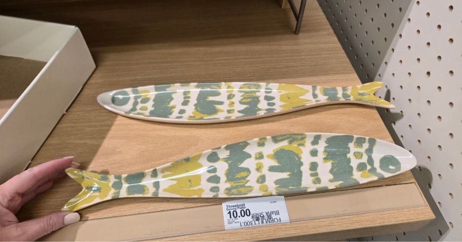 two green, yellow, and white Threshold Fish Dish Serving Platters on shelf in store