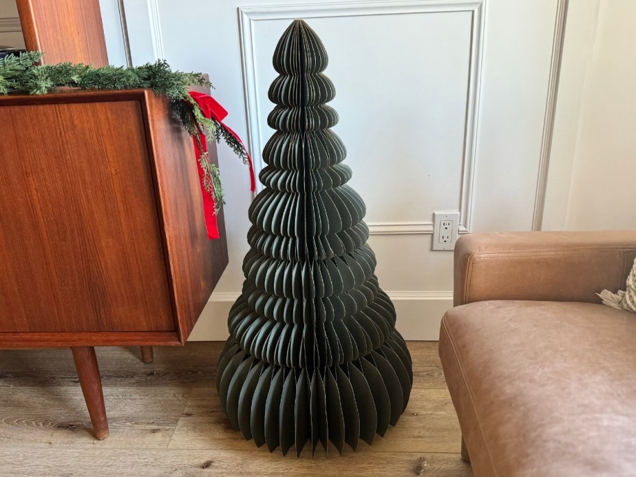 a green paper Christmas tree in a living room