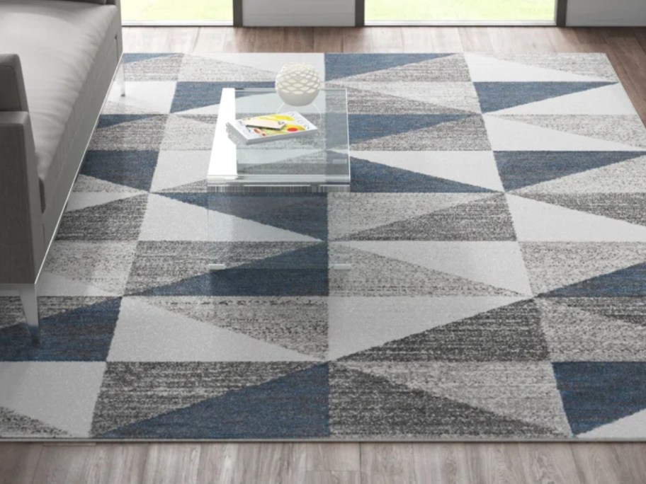 a white, grey and blue triangle geometric print area rug in a living room