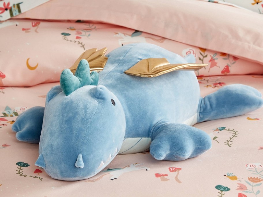 weighed dragon plush displayed on top of the bed