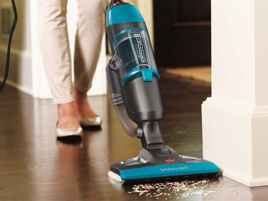 person using a teal and black Bissell steam mop