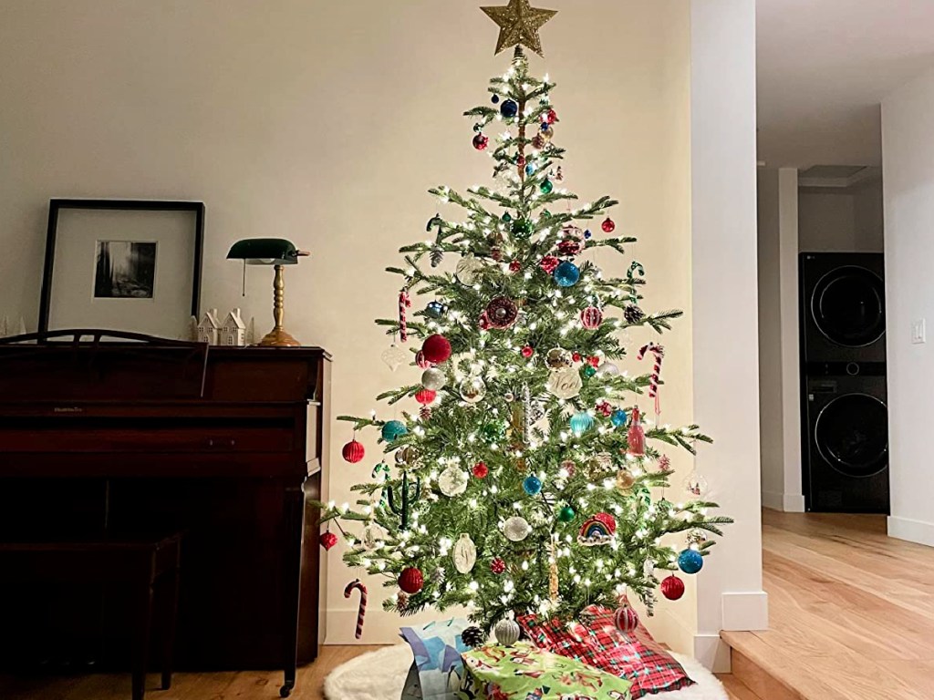 large christmas tree decorated with lights and ornaments in living room