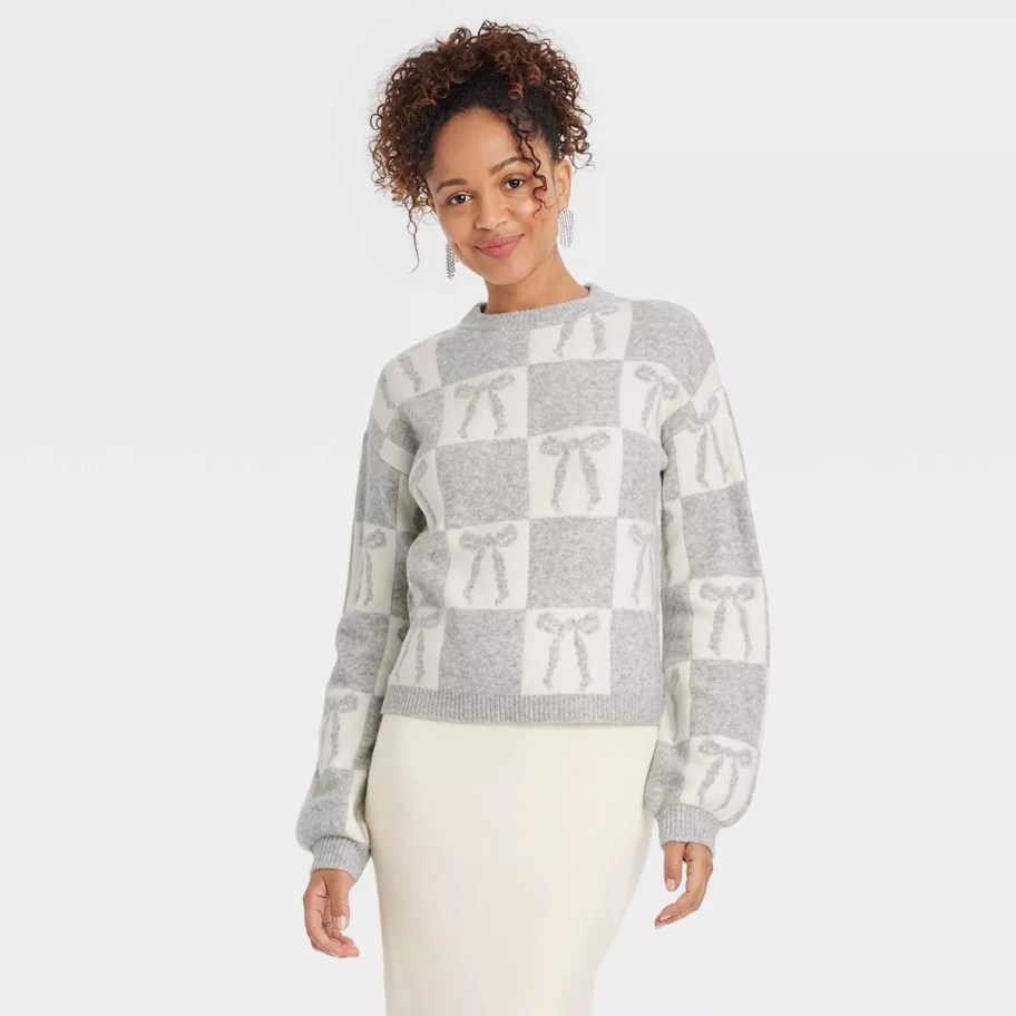 woman modeling gray and white bow sweater