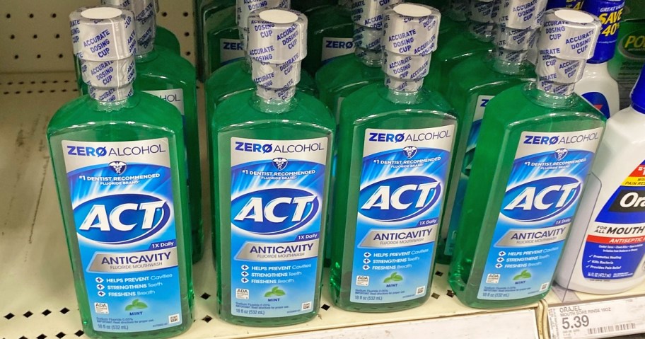 multiple green bottles of ACT Zero Alcohol Mouthwash on store shelf