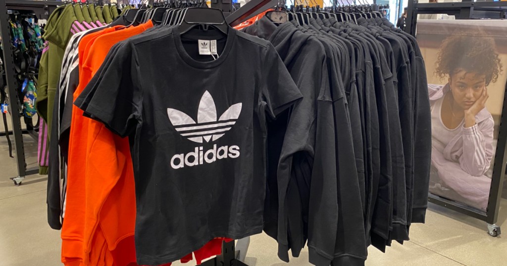 black adidas shirt hanging in store