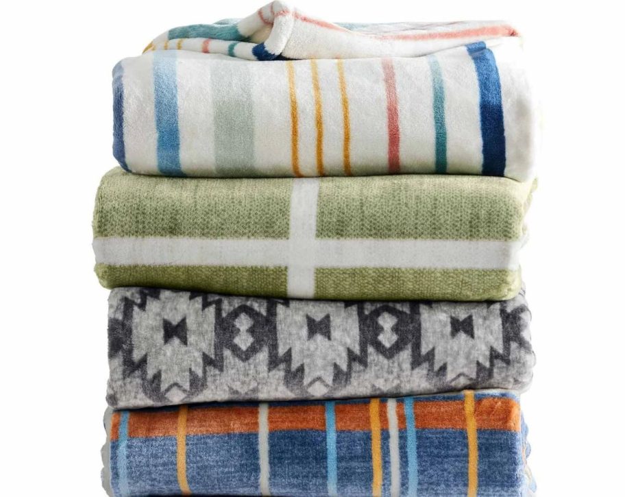  a stack of folded assorted throw blankets 