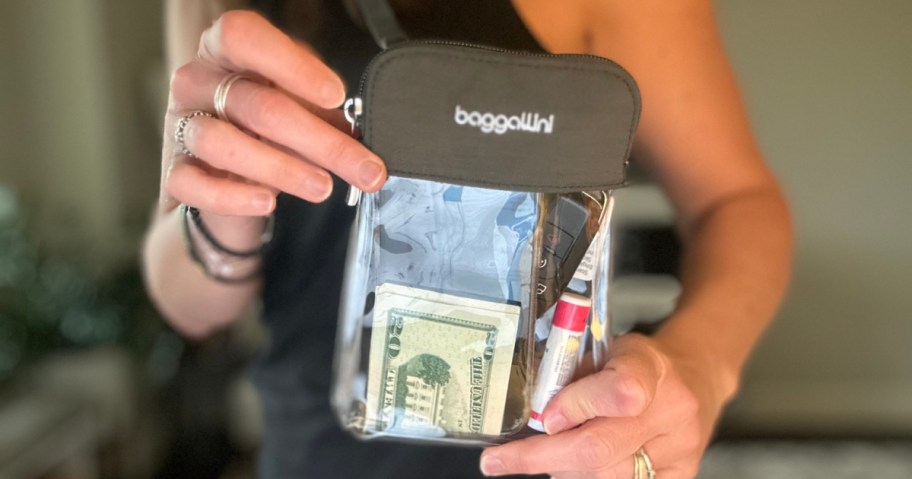 woman holding Baggallini clear bag filled with money and chapstick