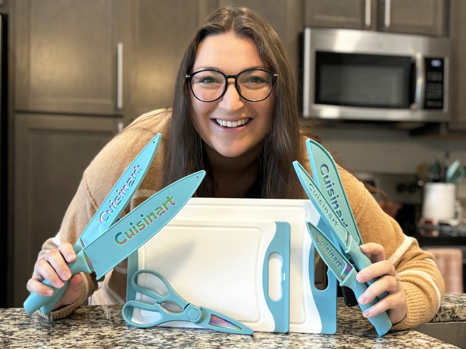 woman holding up teal kitchen knives with cutting board set