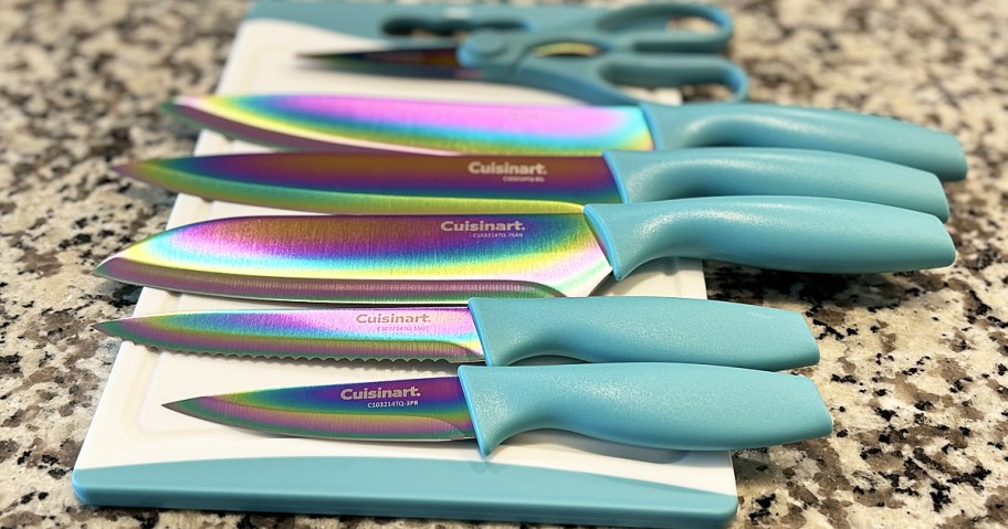 iridescent knife set with teal handles laid out on top of cutting board