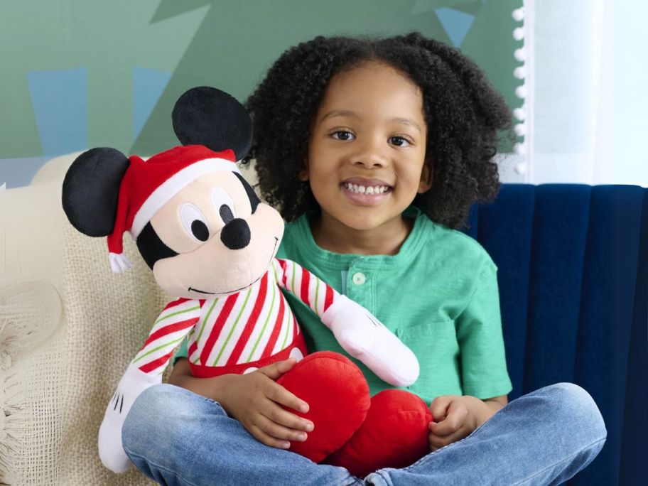 girl holding Disney Holiday Mickey Mouse Plush