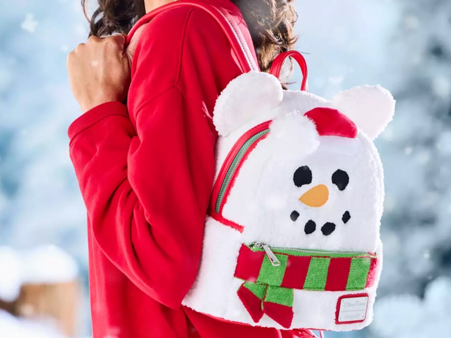 woman in a red top with a white disney snowman backpack