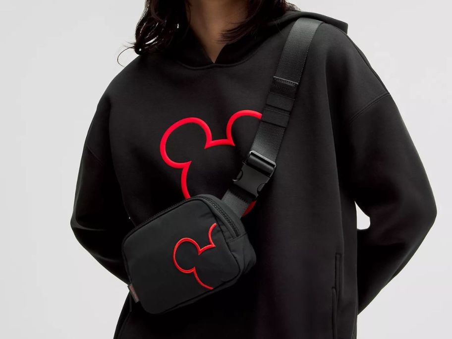 a woman wearing a black disney lululemon belt bag 