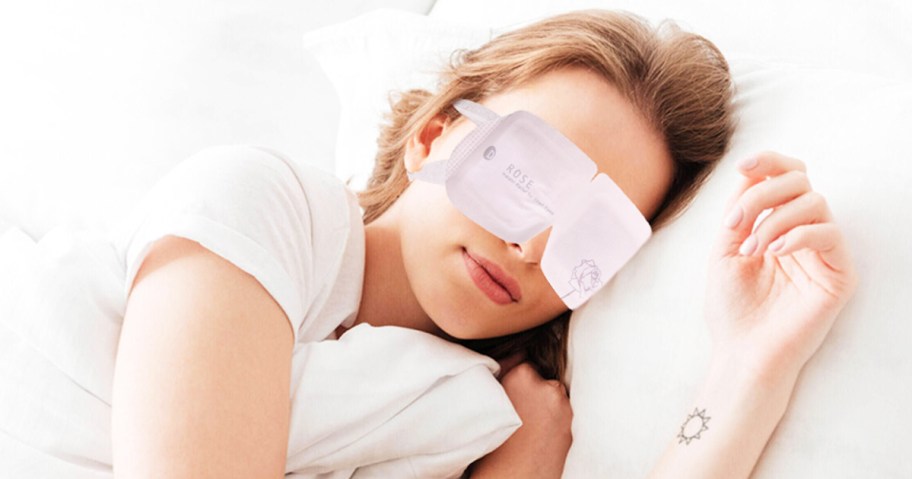 woman laying in bed wearing a self-heating eye mask