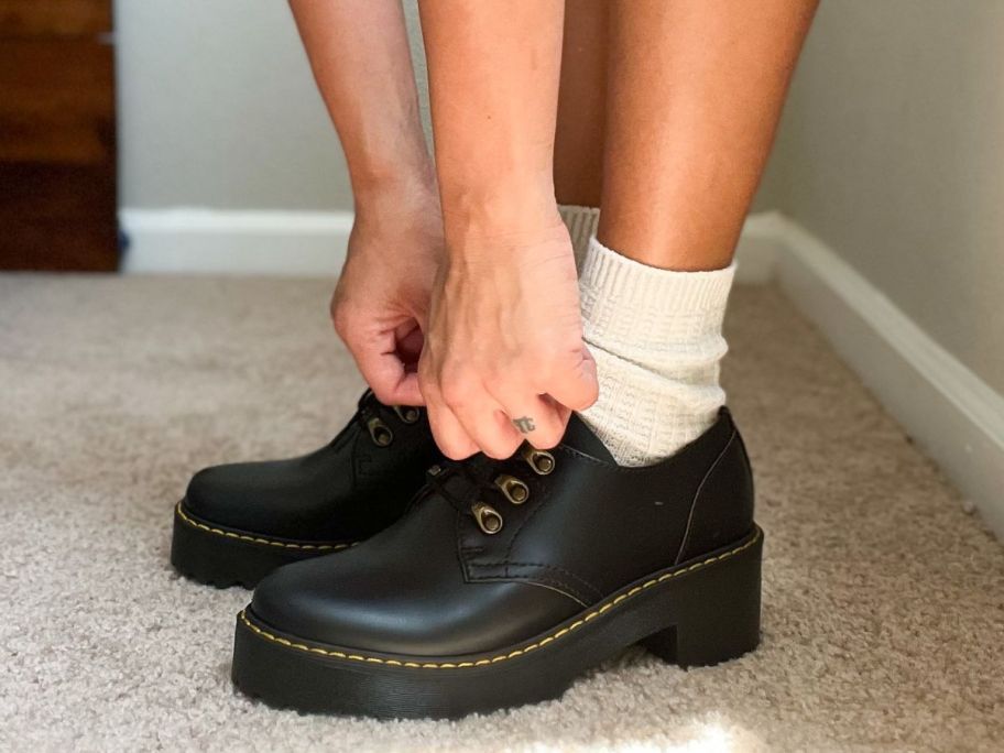 Woman tying her Dr. Martens shoes