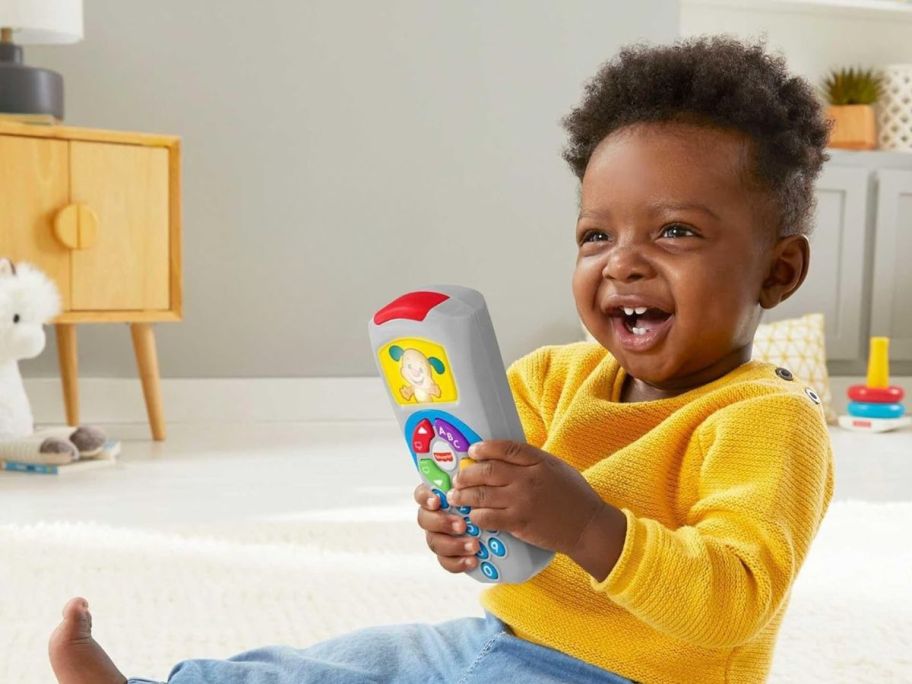 kid playing with Fisher-Price Laugh & Learn Puppy's Remote Pretend TV Control