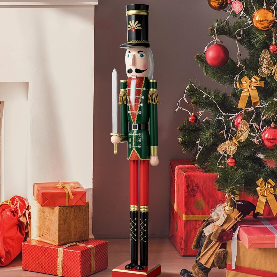 a tall wooden Nutcracker figure by a Christmas tree