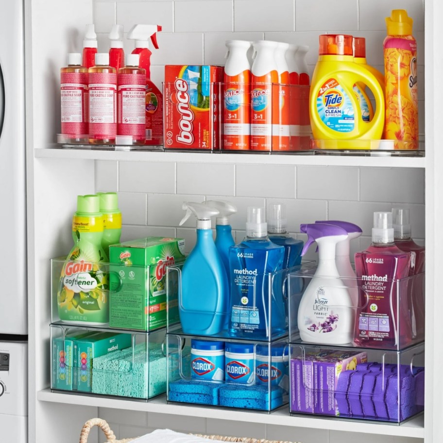 a wall shelf in a laundry room with clear storage containers with laundry items in them