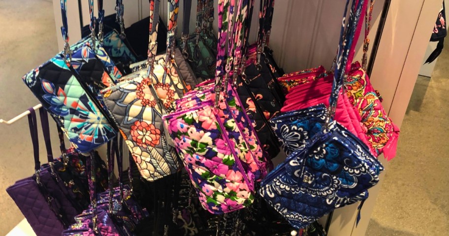 Vera Bradley wristlets in various colors and patterns on a store display wall