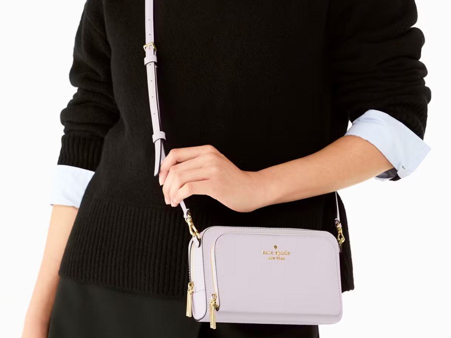 woman in a black sweater with a light grey crossbody bag