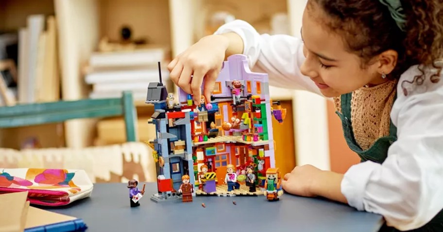 girl playing with LEGO Harry Potter Diagon Alley: Weasleys' Wizard Wheezes set