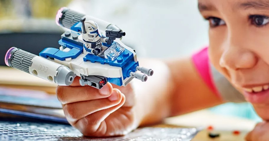 boy playing with LEGO Star Wars Captain Rex Y-Wing Microfighter