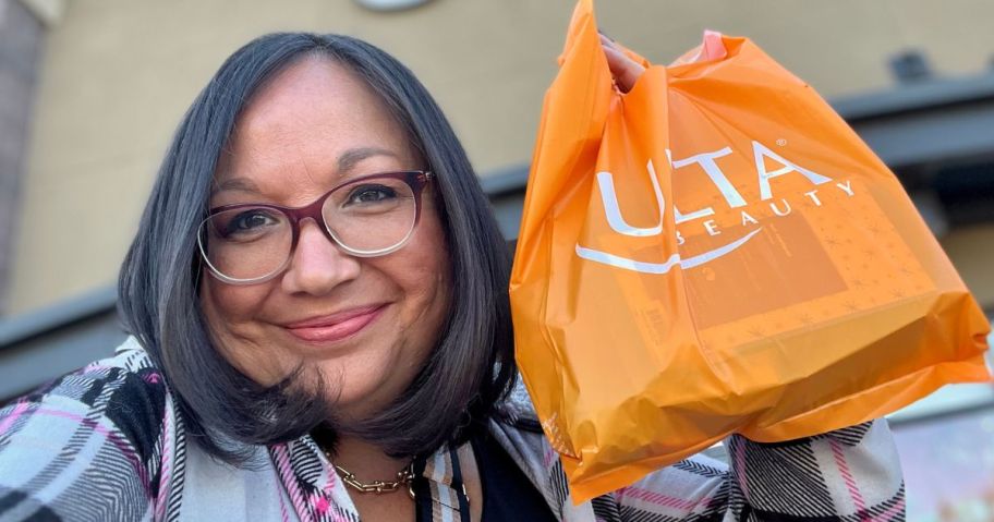 Woman holding up an Ulta Beauty Bag