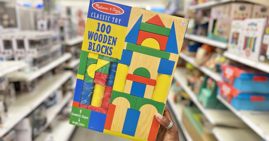 hand holding up Melissa & Doug Wooden Building Blocks Set in store