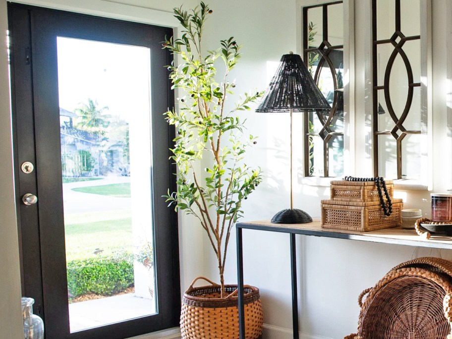 faux olive tree in a basket by front door