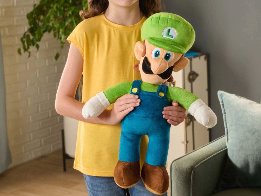 Girl holding a plush Luigi Pillow Buddy