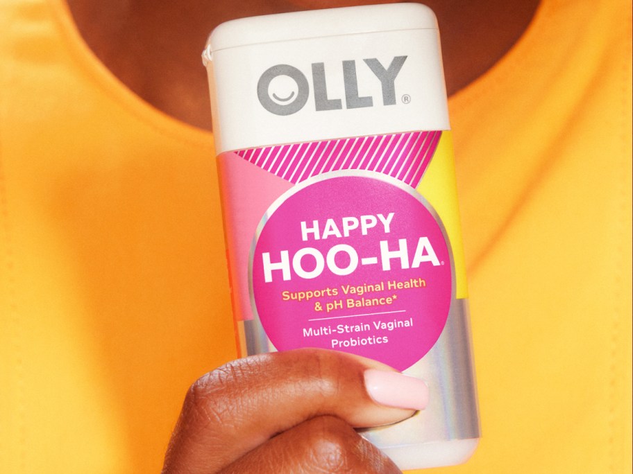 woman in yellow shirt holding a bottle of OLLY Happy Hoo-Ha Capsules